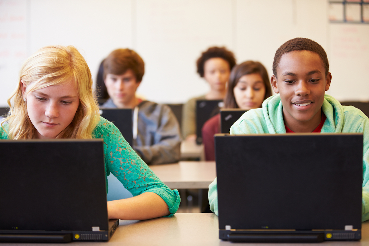 high school aged students behind laptops